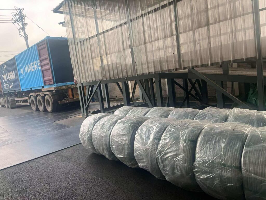 galvanized iron wire container loading palletized coils secured with steel strapping for shipping