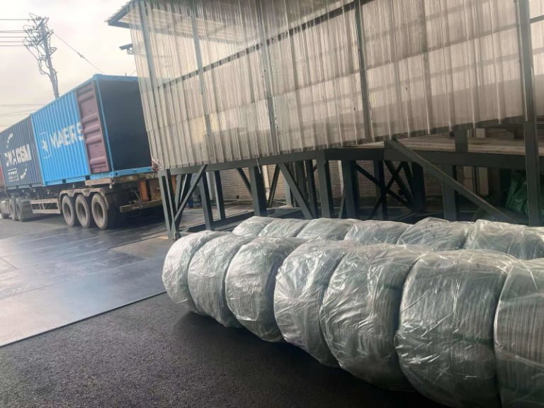 galvanized iron wire container loading palletized coils secured with steel strapping for shipping